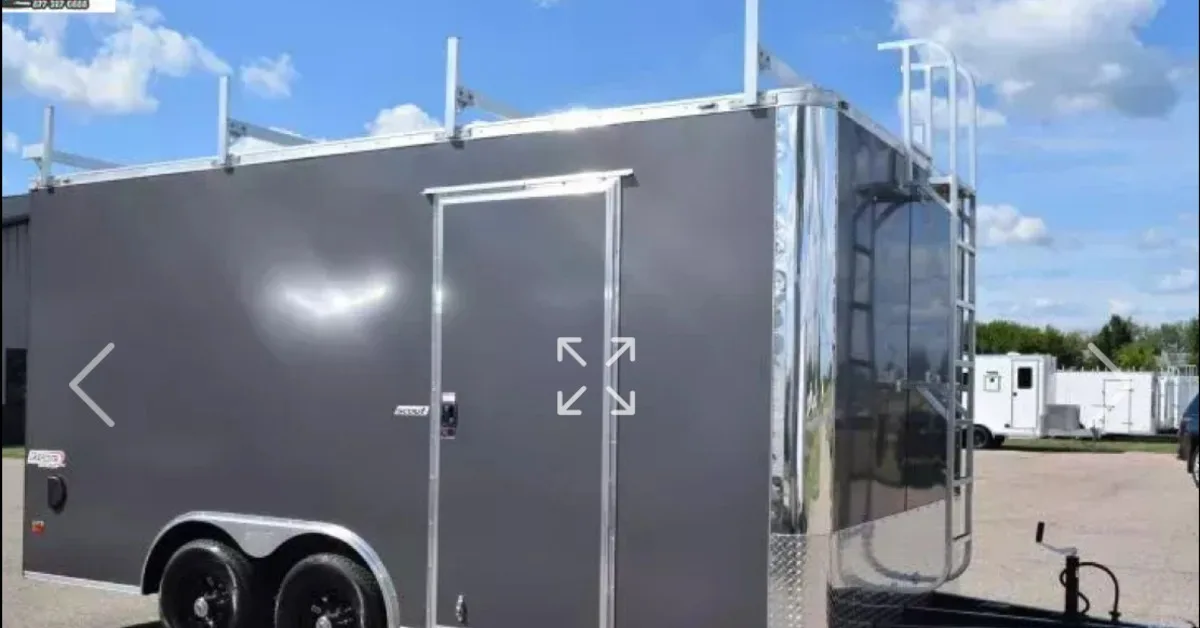 A dark gray contractor trailer sits in the parking lot. There is a door on the side of the trailer for entry.