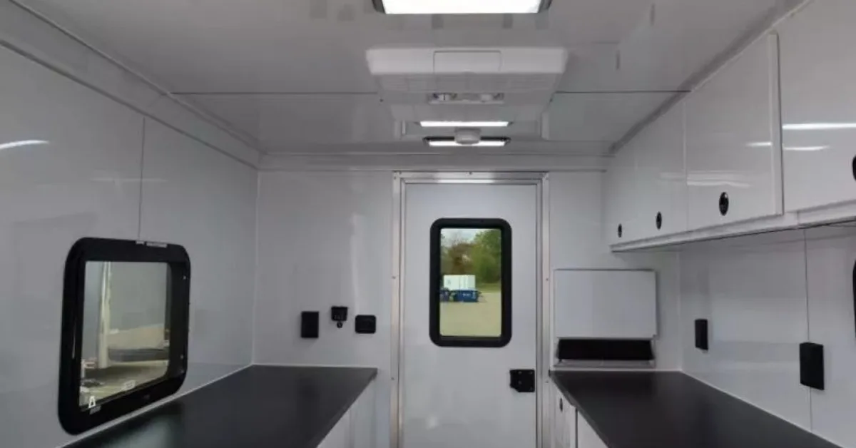 The interior of a fiber splicing trailer. Each side has a counter and there's an exit door in the back center.