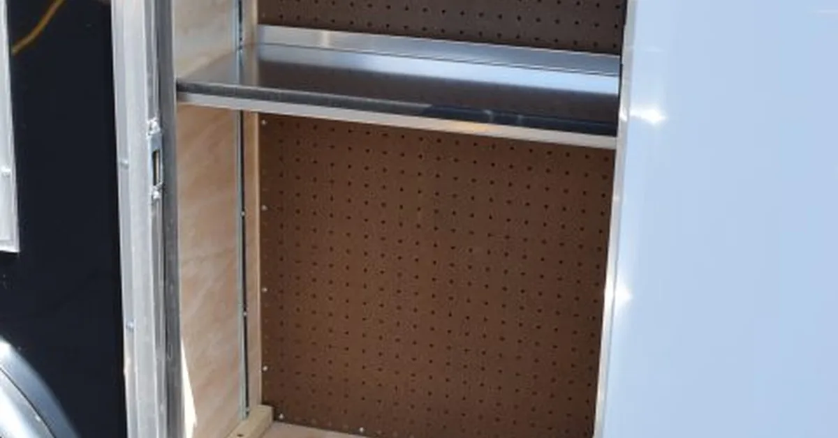 An exterior door panel on a contractor tool trailer. The opened door features a storage compartment.