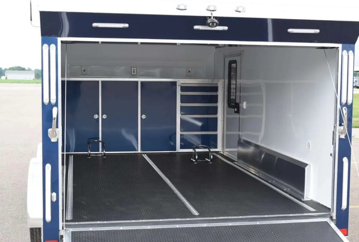 Made to Last: A Custom Trailer Material Selection Guide The interior of a customized work contractor trailer. There are custom cabinets along the back wall and an open floor.